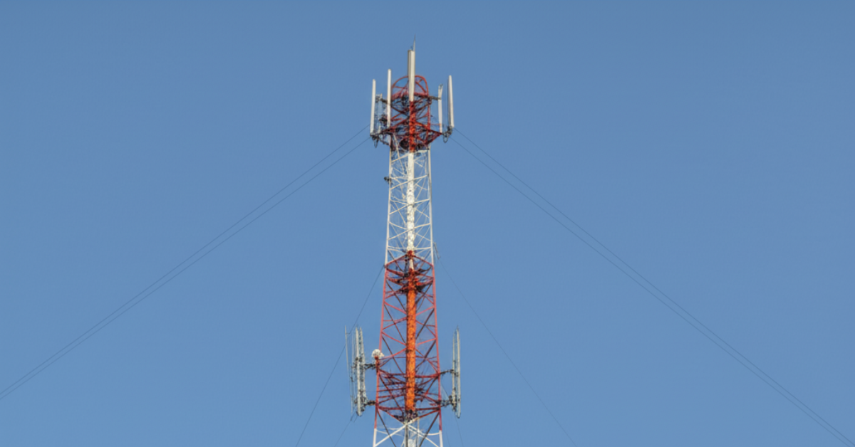 Kontraktor sandblasting sedang melakukan pembersihan karat atau cat lama pada struktur baja sebuah menara telekomunikasi