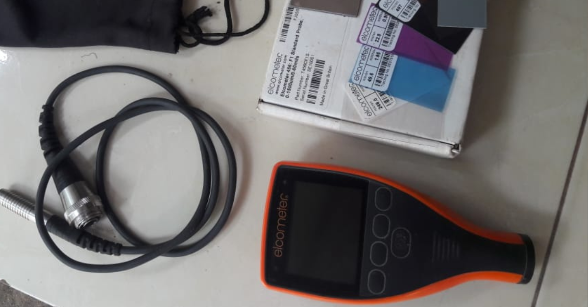 Alat ukur ketebalan cat Elcometer lengkap dengan probe, pelat kalibrasi, dan kotak kemasan, digunakan untuk pengujian DFT (Dry Film Thickness) pada permukaan logam.